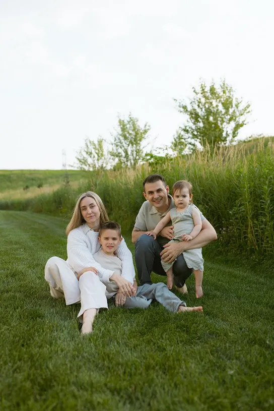 The two founders with their children, sitting in the grass on a summer evening.
